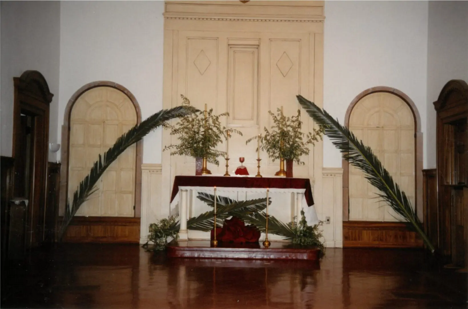 A church altar with palm leaves and candles.