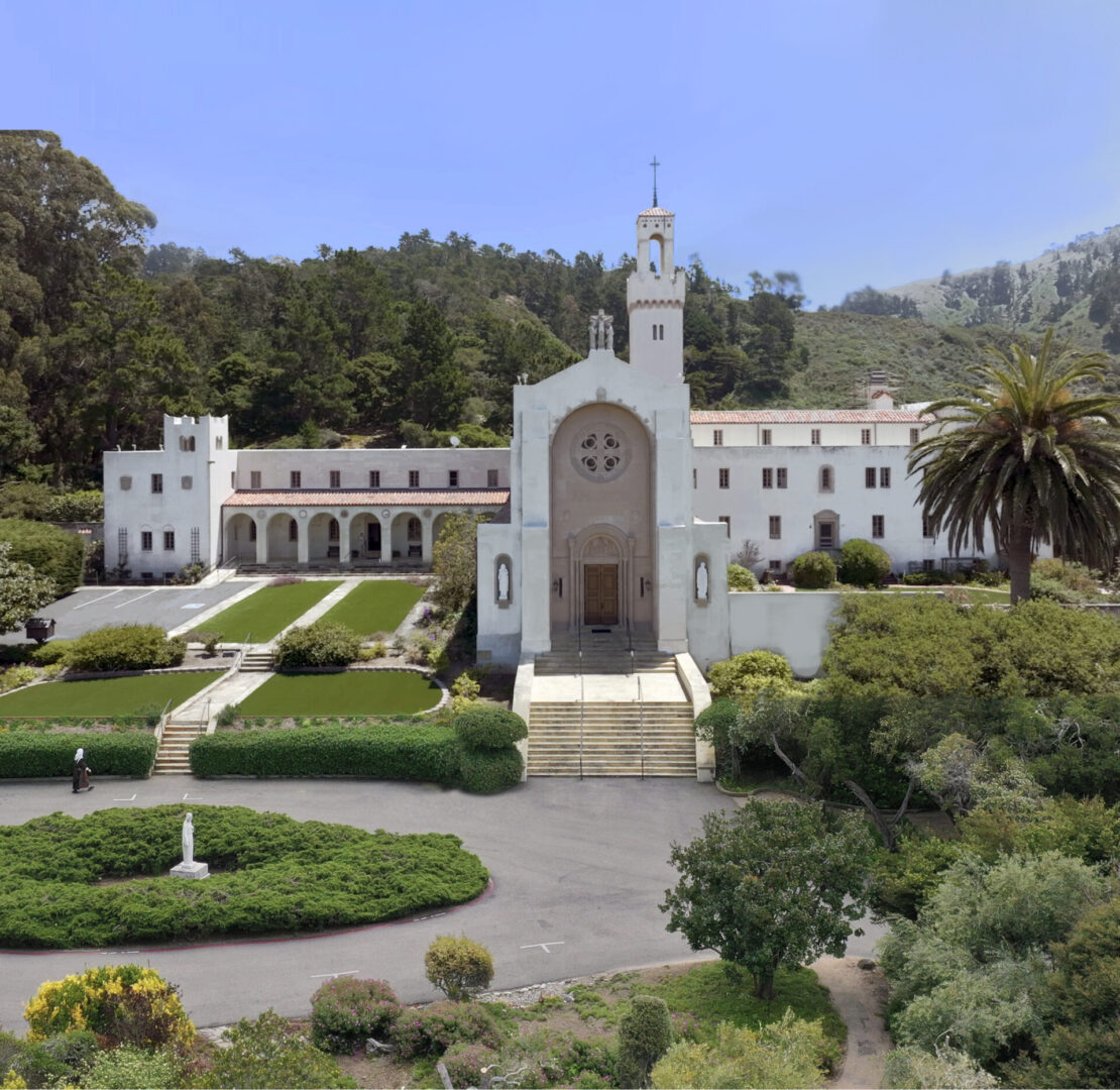 A large white church with trees in the background