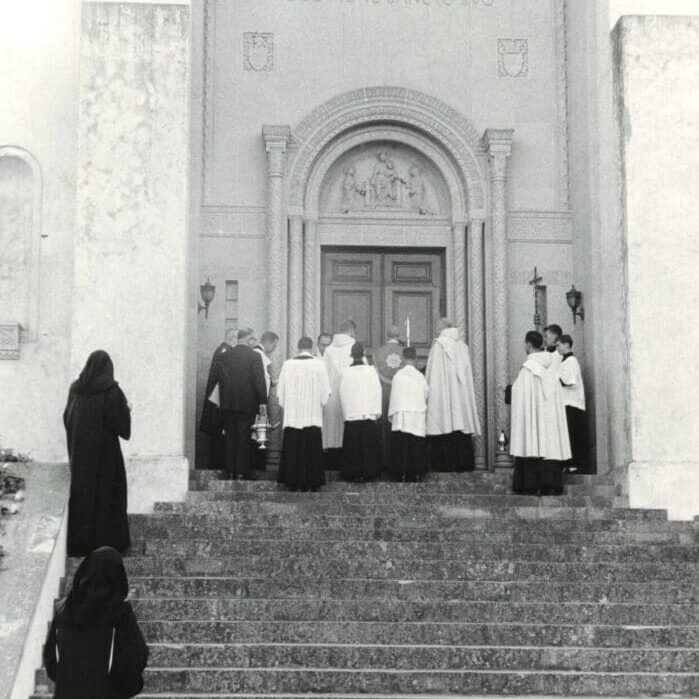 A group of people standing on steps outside.