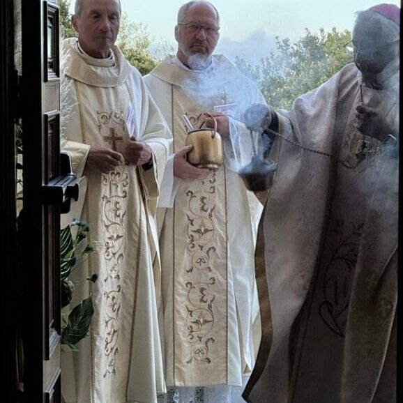 Two men in white robes standing next to each other.